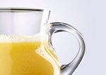 Close-up of orange juice in glass jar, studio shot