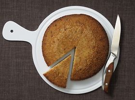 Kuchen und Kuchenstück auf Teller mit Messer