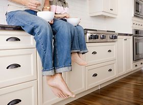 Küche - Zwei Personen sitzen auf Arbeitsplatte