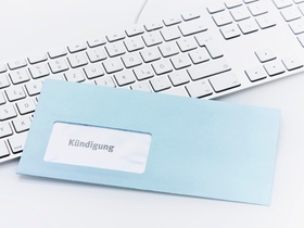 Blauer Kündigungsbrief liegt auf Tastatur
