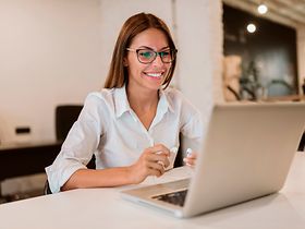 lächelnde Frau vor Laptop
