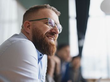 lächelnder bärtiger Mann mit Brille