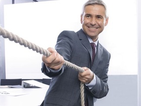 Mann beim Tauziehen im Buero