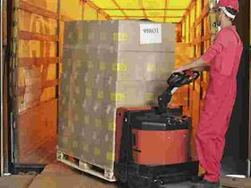 Lagerarbeiter verlaedt Kartons mit Hubwagen in Lkw