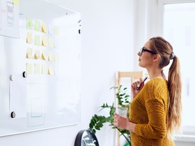Young businesswoman planning on whiteboard in startup office