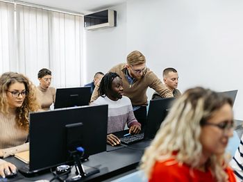 Lehrer erklärt Schüler Computer
