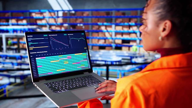 Logistik_Produktion_Frau mit Laptop in Lagerhalle