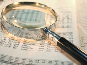 Lupe liegt auf Börsenkursen in Zeitung