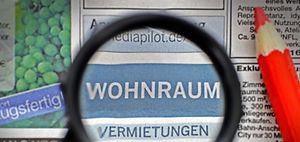 Lupe und Rotstift über der Zeitungsrubrik Wohnungen