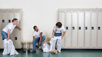 Männer in weißen Overals in der Umkleidekabine