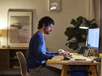 Männlicher Entrepreneur benutzt PC auf dem Tisch