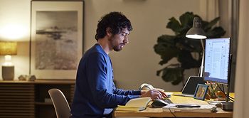 Männlicher Entrepreneur benutzt PC auf dem Tisch