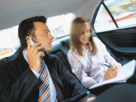 Manager mit Sekretaerin im Auto