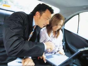 Manager mit Sekretaerin im Auto