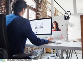Young businessman and woman working together in office