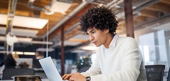 Mann am Laptop im Büro