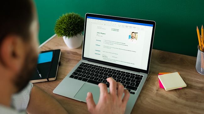 Mann arbeitet am Laptop am Lebenslauf