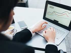 Mann arbeitet an Laptop mit Grafiken