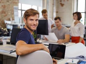 Mann arbeitet mit Kollegen im Büro