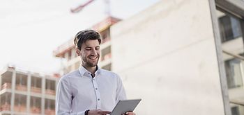 Mann Baustelle Laptop Hochbau Mehrfamilienhaus Kran