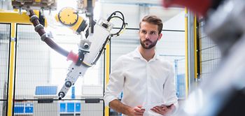 Mann bedient Roboter