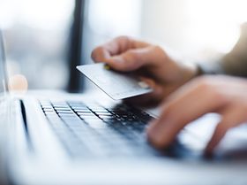 Mann benutzt Laptop mit EC Karte