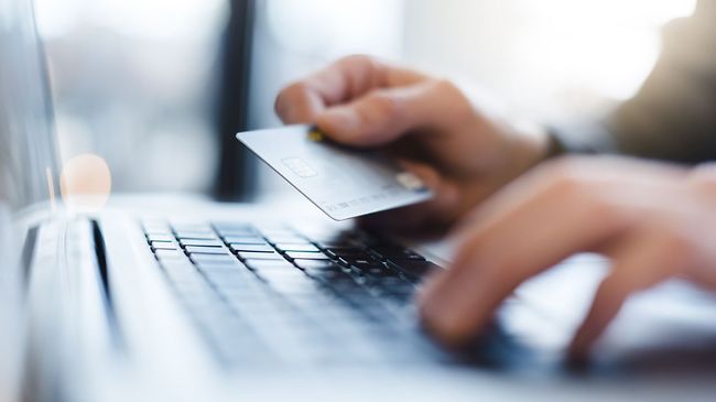 Mann benutzt Laptop mit EC Karte