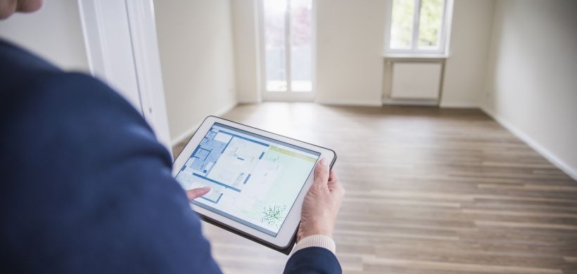 Mann benutzt Tablet in leerer Wohnung