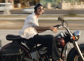 Mann fährt auf altem Motorrad