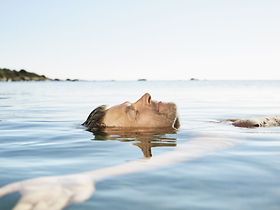Mann gleitet entspannt auf Rücken in See