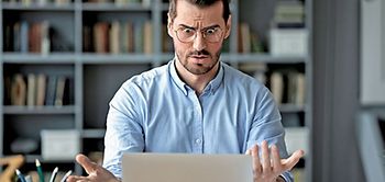 Mann guckt erstaunt in sein Laptop