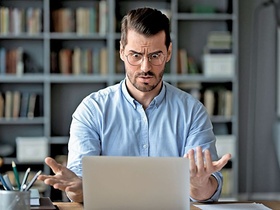 Mann guckt erstaunt in sein Laptop