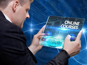 Mann hält futuristisches Tablet in der Hand mit Online Courses