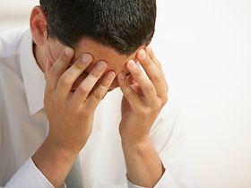 Mann hält Hände vor Gesicht