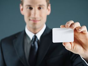 Mann hält Scheckkarte vor sich in der Hand