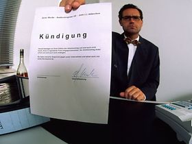 Mann hält seine fristlose Kündigung in die Kamera
