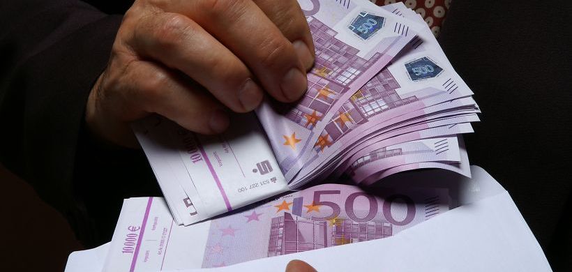 Mann holt 500er Geldscheine aus Briefumschlag