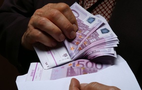 Mann holt 500 Euro Geldscheine aus Briefumschlag