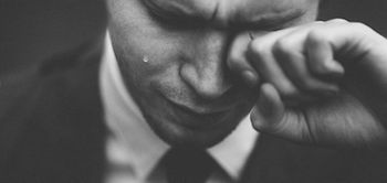 Mann im Anzug vergießt Träne