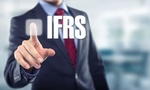 Mann im Anzug zeigt auf Schriftzug IFRS