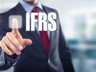 Mann im Anzug zeigt auf Schriftzug IFRS
