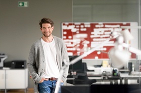 Dynamic businessman standing in office, smiling