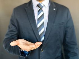 Mann in Anzug mit geöffneter Handfläche