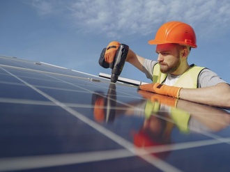 Mann installiert Photovoltaik auf Dach, Solarstrom