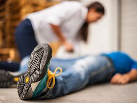 Mann liegt am Boden mit Herzinfarkt