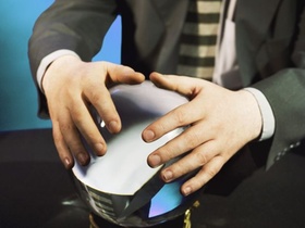 Mann mit Anzug, Hände an Glaskugel