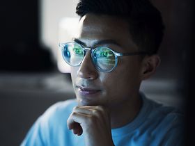 mann mit brille analysiert zahlen am bildschirm