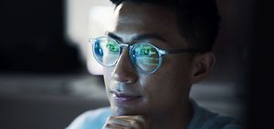 mann mit brille analysiert zahlen am bildschirm