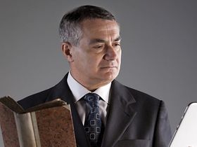 Mann mit Buch und Tablet