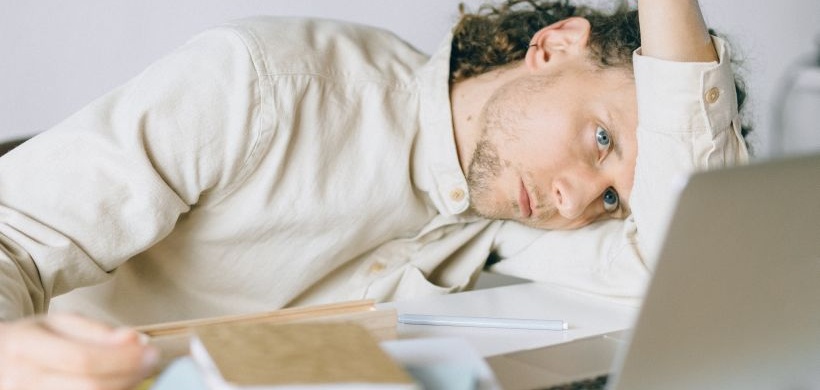 Mann mit Burnout vor Laptop